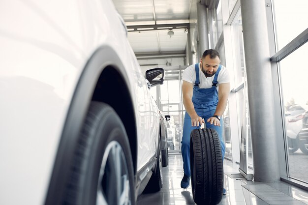 L'uomo bello in un'uniforme blu controlla l'automobile