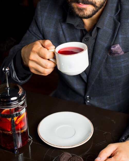 L'uomo beve una tazza di tè alla frutta