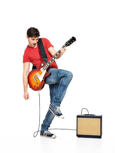 L'uomo chitarrista suona la chitarra elettrica con emozioni luminose, isolatade su sfondo bianco