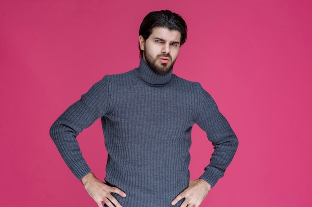 L'uomo con i capelli lunghi e la barba apre le mani e sembra confuso o inesperto.