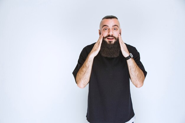 L'uomo con la barba diventa estremamente felice a causa di qualcosa.