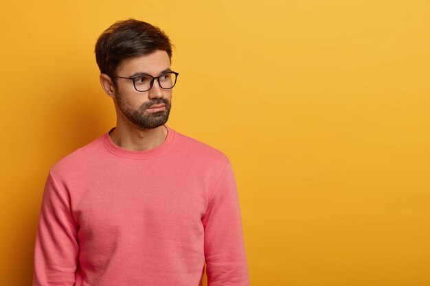 L'uomo con la barba lunga guarda pensieroso da parte, pensa ai piani futuri