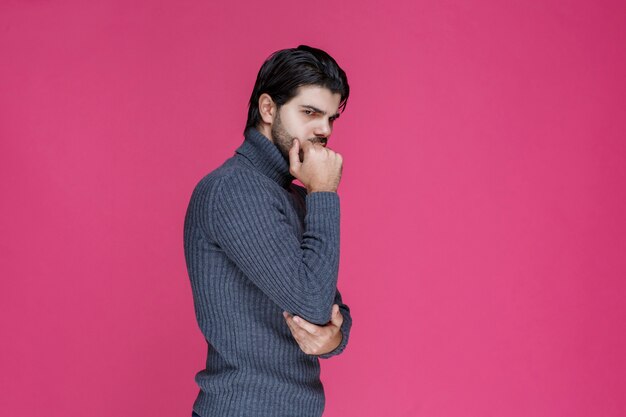 L'uomo con la barba nera sembra esausto e annoiato.