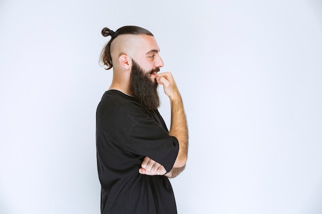 L'uomo con la barba sembra pensieroso e sognante.