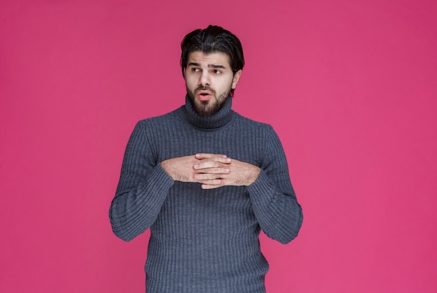 L'uomo con la barba sembra perso e pensieroso.