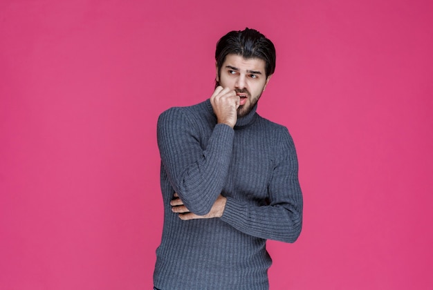 L'uomo con la barba sembra perso e pensieroso.