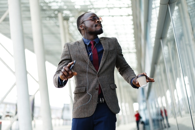 L&#39;uomo d&#39;affari afroamericano felice balla mentre ascolta la musica