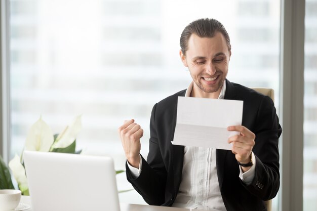 L&#39;uomo d&#39;affari felice celebra ricevere le buone notizie di affari