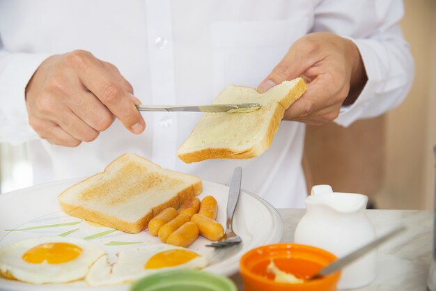 L&#39;uomo d&#39;affari mangia la colazione americana in un hotel