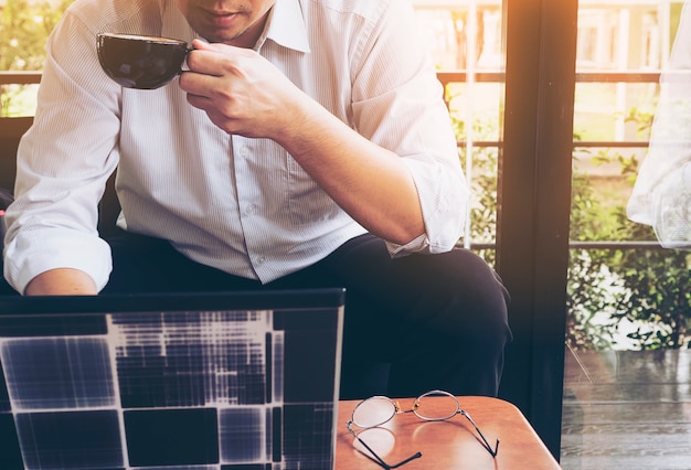 L&#39;uomo d&#39;affari sta lavorando con il suo computer nella caffetteria