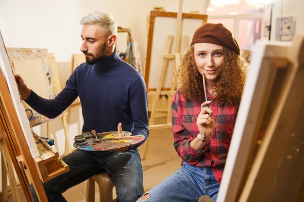 L'uomo disegna un dipinto e una ragazza sorride