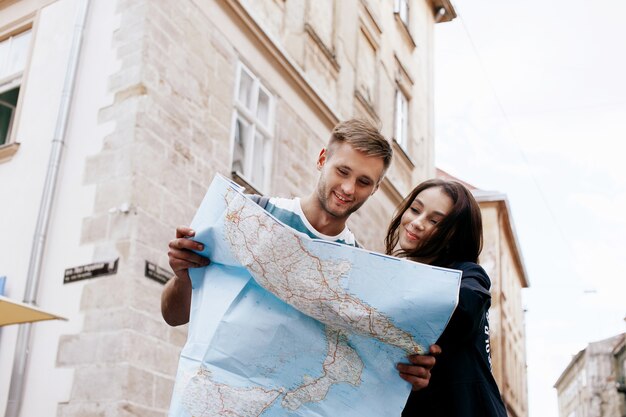 L&#39;uomo e la donna guardano la mappa in piedi nella città vecchia