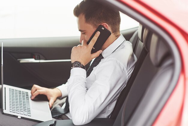 L'uomo è un uomo che lavora su un laptop e prova su dispositivi mobili.