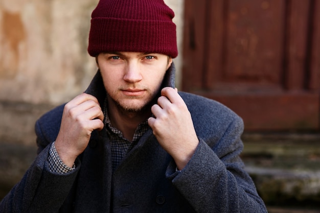 L&#39;uomo fissa il suo colletto in posa con un cappello rosso