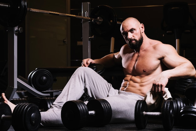 L&#39;uomo in pantaloni felpati tra barbells