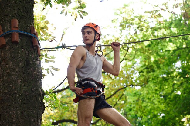L&#39;uomo in un casco arancione è pronto a scalare la corda