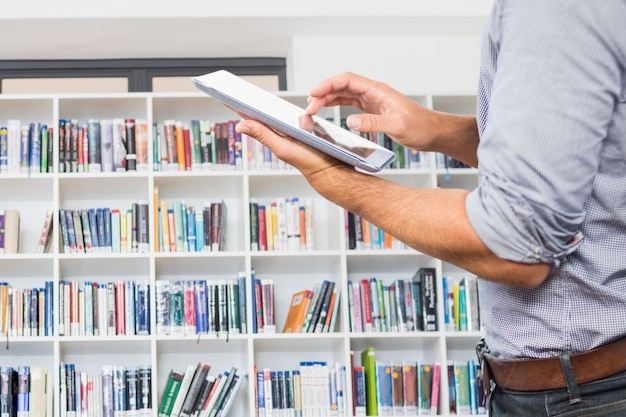 L&#39;uomo in una libreria con una tavoletta