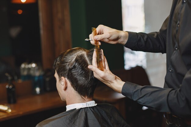 L'uomo lavora con i capelli. Parrucchiere con un cliente.