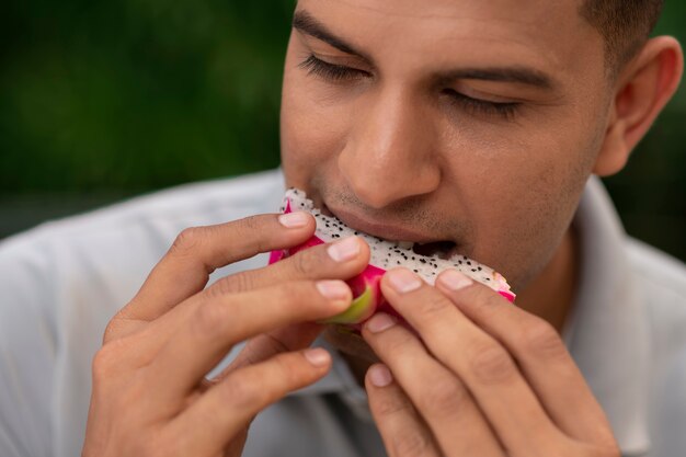 L'uomo mangia la frutta del drago all'aperto