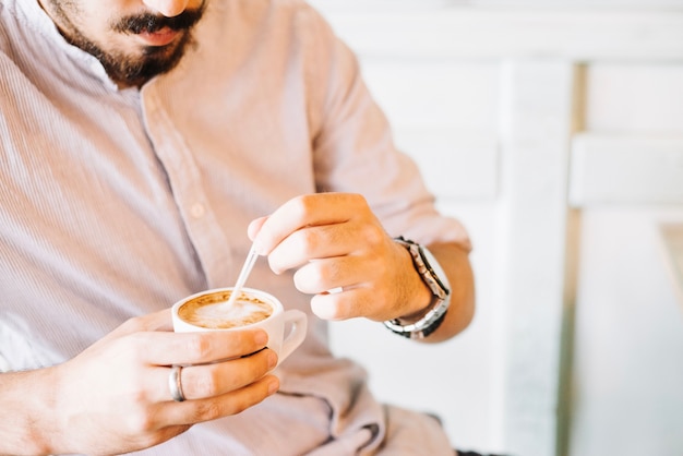 L&#39;uomo mescolando il caffè