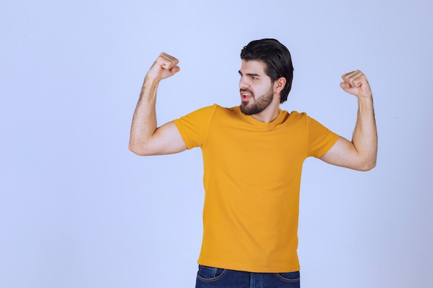 L'uomo mostra i muscoli delle braccia e si sente potente.
