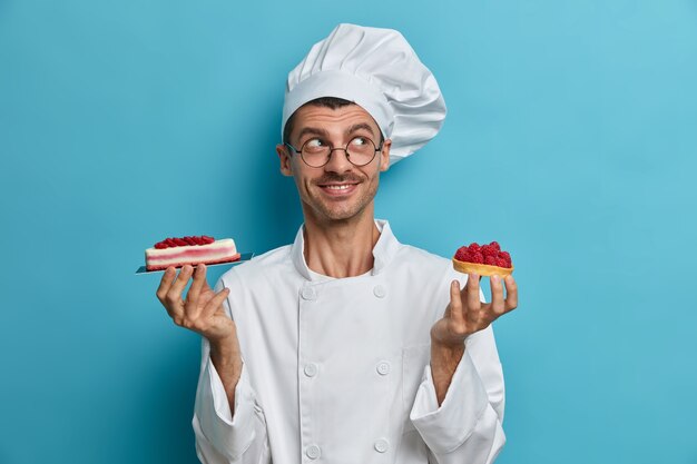 L'uomo pasticcere sta con deliziose torte