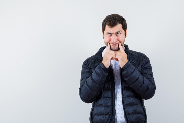 L'uomo pensante tiene gli indici intorno alla bocca su sfondo bianco