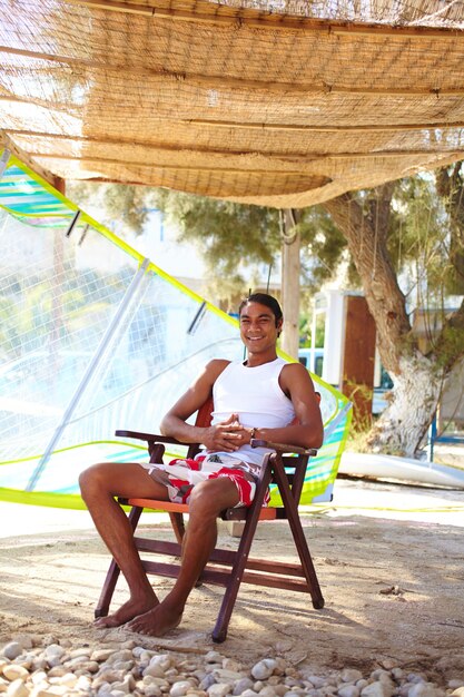 L&#39;uomo seduto in poltrona sulla spiaggia