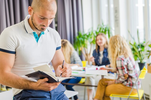 L&#39;uomo si è concentrato sulla scrittura nel blocchetto per appunti