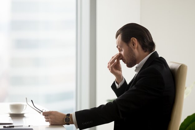 L&#39;uomo si sente affaticato negli occhi dopo il lavoro in ufficio
