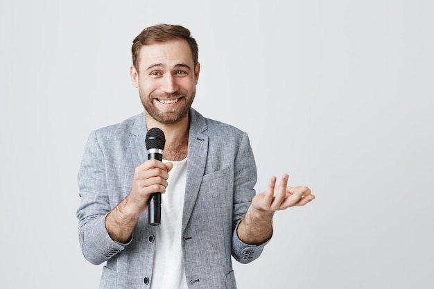 L'uomo sorridente con il microfono esegue in piedi