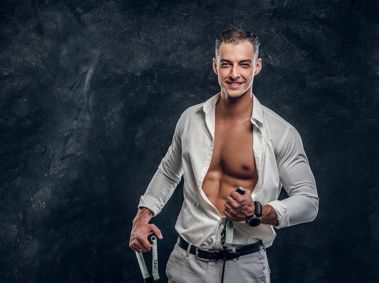 Foto gratuito l'uomo sorridente felice in camicia bianca sta mostrando la sua confezione da sei perfetta quando ha aperto la camicia.