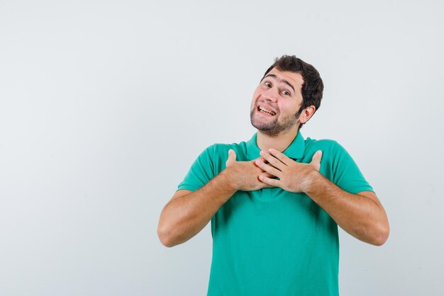 L'uomo sorridente sta stringendo le mani sul petto su sfondo bianco