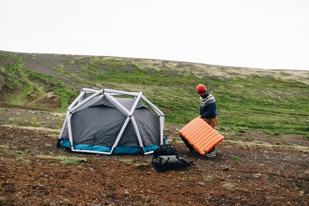 L'uomo sta accanto alla moderna tenda in Islanda