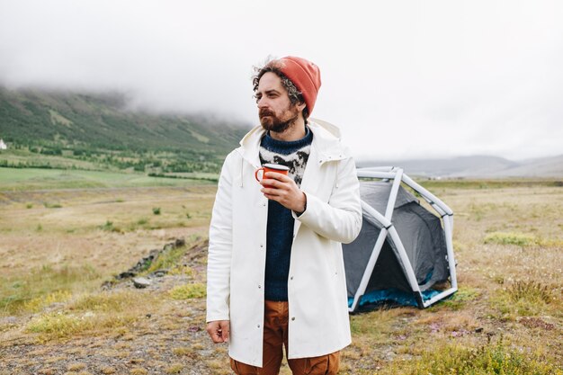 L'uomo sta accanto alla moderna tenda in Islanda