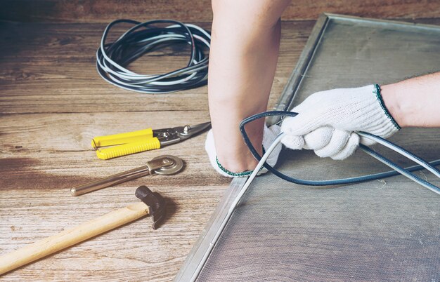 l&#39;uomo sta lavorando con l&#39;installazione di zanzariera