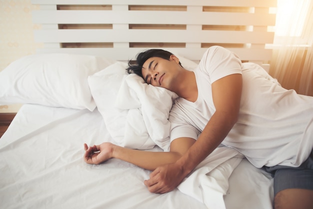 L&#39;uomo stanco che si trova giù dorme a letto