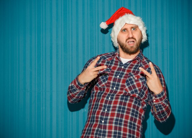 L'uomo supponente di natale che porta un cappello della Santa