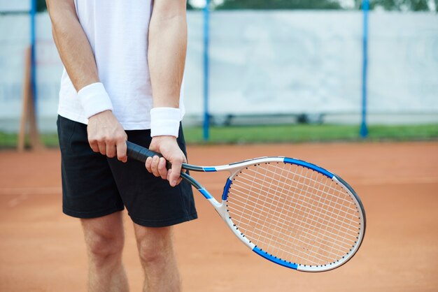 L'uomo tiene in mano una racchetta da tennis