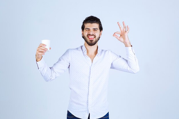 L'uomo tiene in mano una tazza di caffè e ne gode il gusto