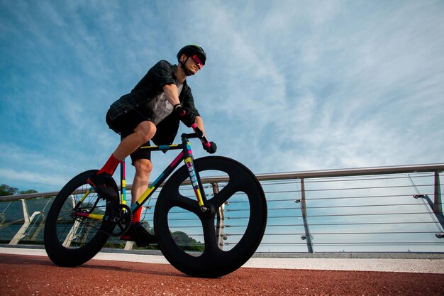 L'uomo va in bicicletta a bridgeL'immagine del ciclista in movimento sullo sfondo al mattino