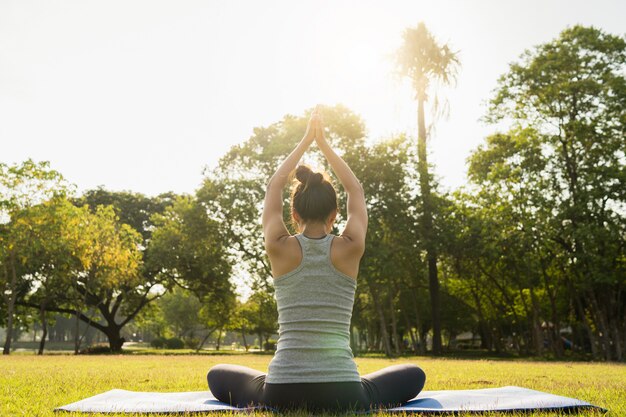 L&#39;yoga della giovane donna asiatica all&#39;aperto mantiene la calma e medita mentre pratica l&#39;yoga