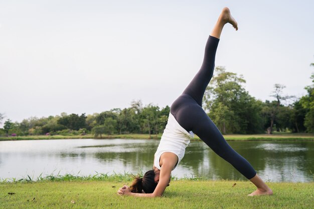 L&#39;yoga della giovane donna asiatica all&#39;aperto mantiene la calma e medita mentre pratica l&#39;yoga