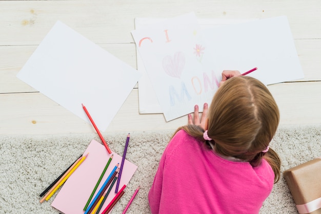 La bambina che disegna amo la mamma su carta