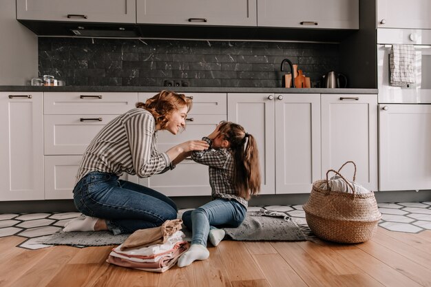 La bambina si coprì gli occhi mentre giocava con la sua amata madre in cucina.