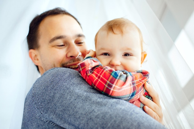 La bambina sorride seduto sulle braccia del padre