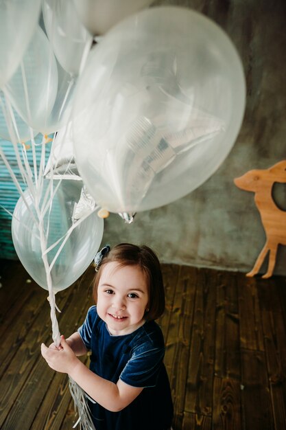 La bambina tiene i palloncini nella stanza