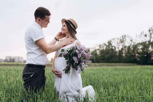 La bella coppia innamorata si guarda e mantiene il bouquet