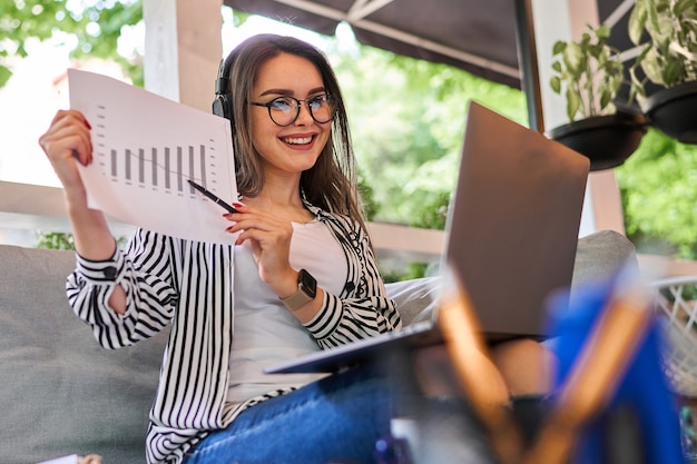 La bella donna lavora a casa con il computer portatile.