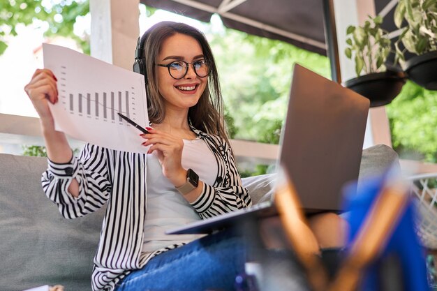 La bella donna lavora a casa con il computer portatile.